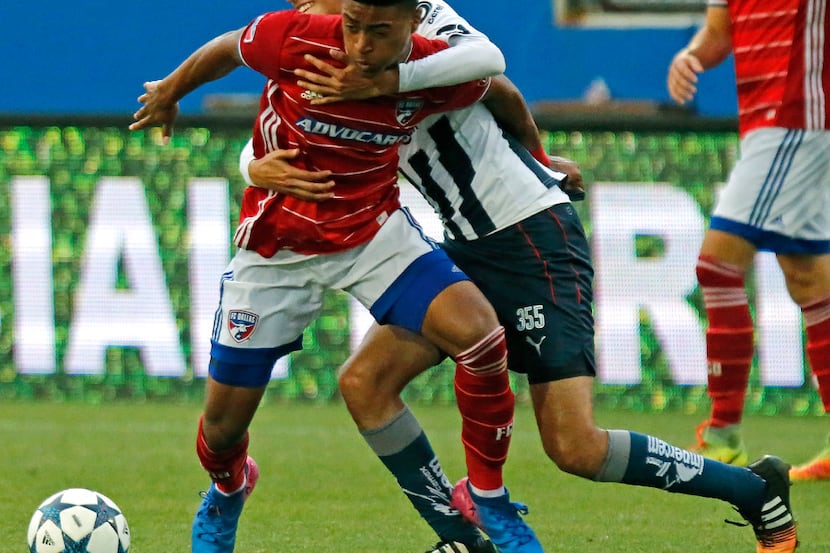 FC Dallas player Shaft Brewer (17) is held by CF Monterrey player Jesus Fernandez Rodriguez...