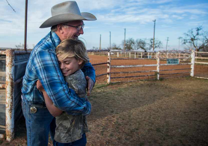 Pastor James Brunson (left) hugs Joseph McClure after a roping outreach event at the Coke...