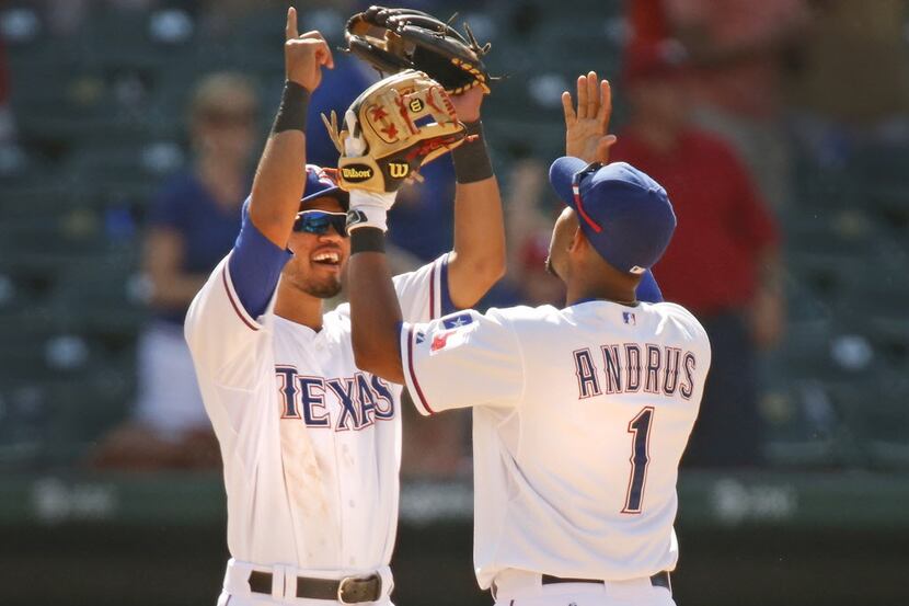 Texas' Luis Sardinas, left, and Elvis Andrus celebrate after the final out during the Texas...