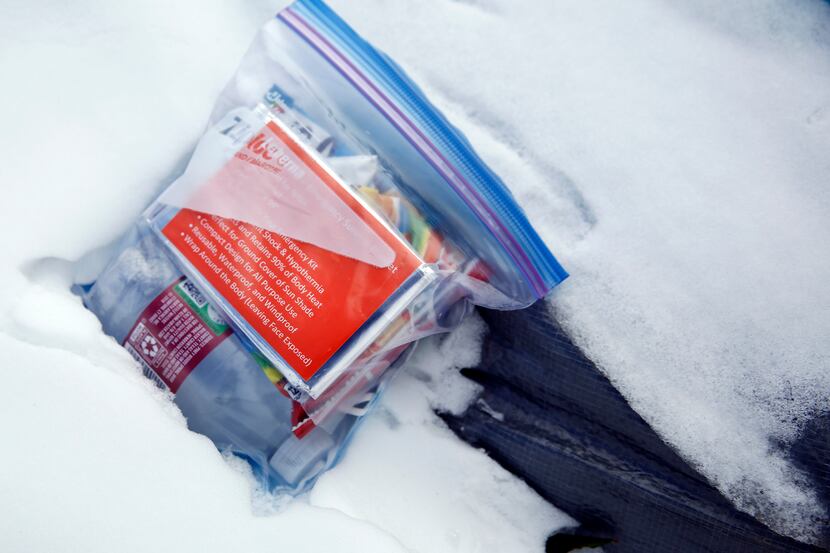 An unopened emergency blanket kit lies on a snow-covered tent pitched along Interstate 30 in...