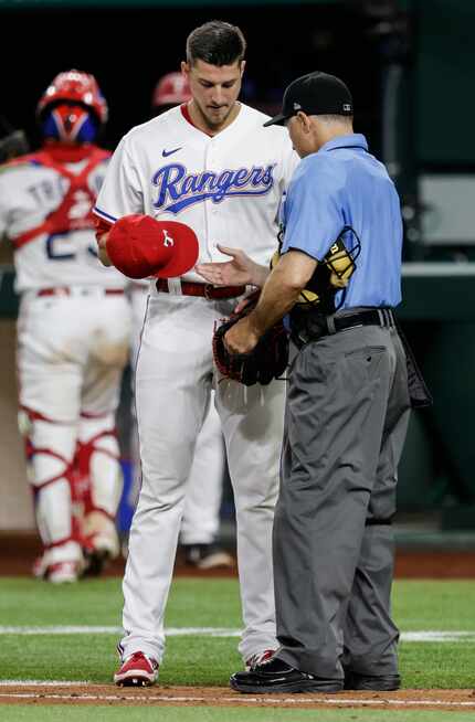Home plate umpire Dan Iassogna inspects Texas Rangers relief pitcher Brett Martin’s (59)...