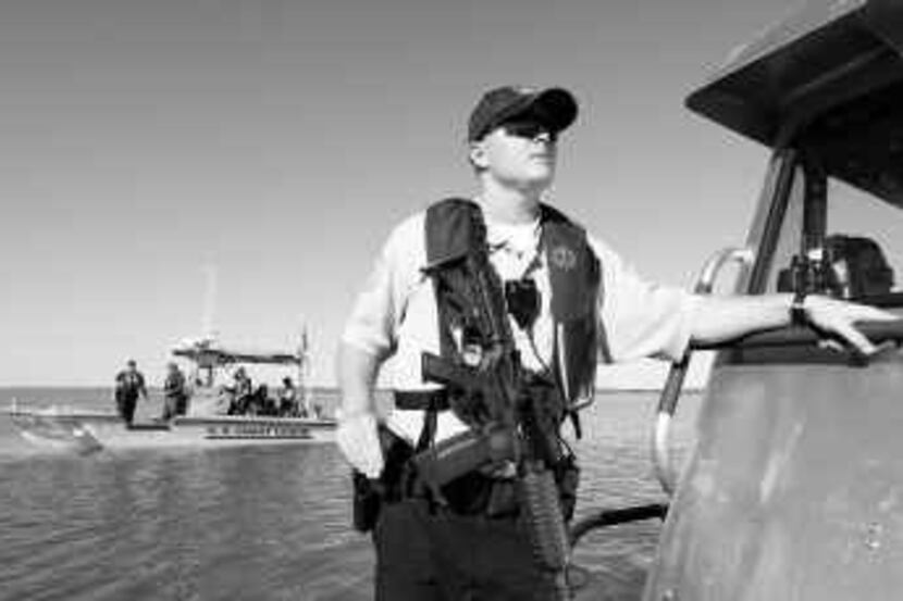  Texas game warden Jake Mort, armed with an M-16, rode aboard a Texas Parks and Wildlife...