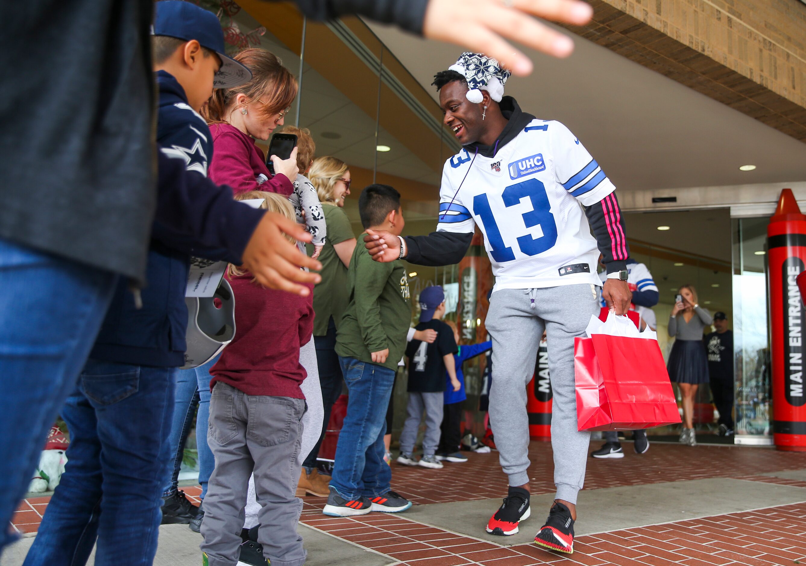 Dallas Cowboys wide receiver Michael Gallup (13) gives high fives to young fans as he makes...