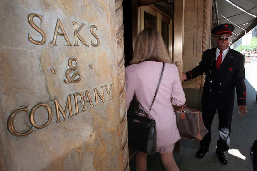 A Saks & Company doorman opens the 50th Street store entrance for customers, in New York,...