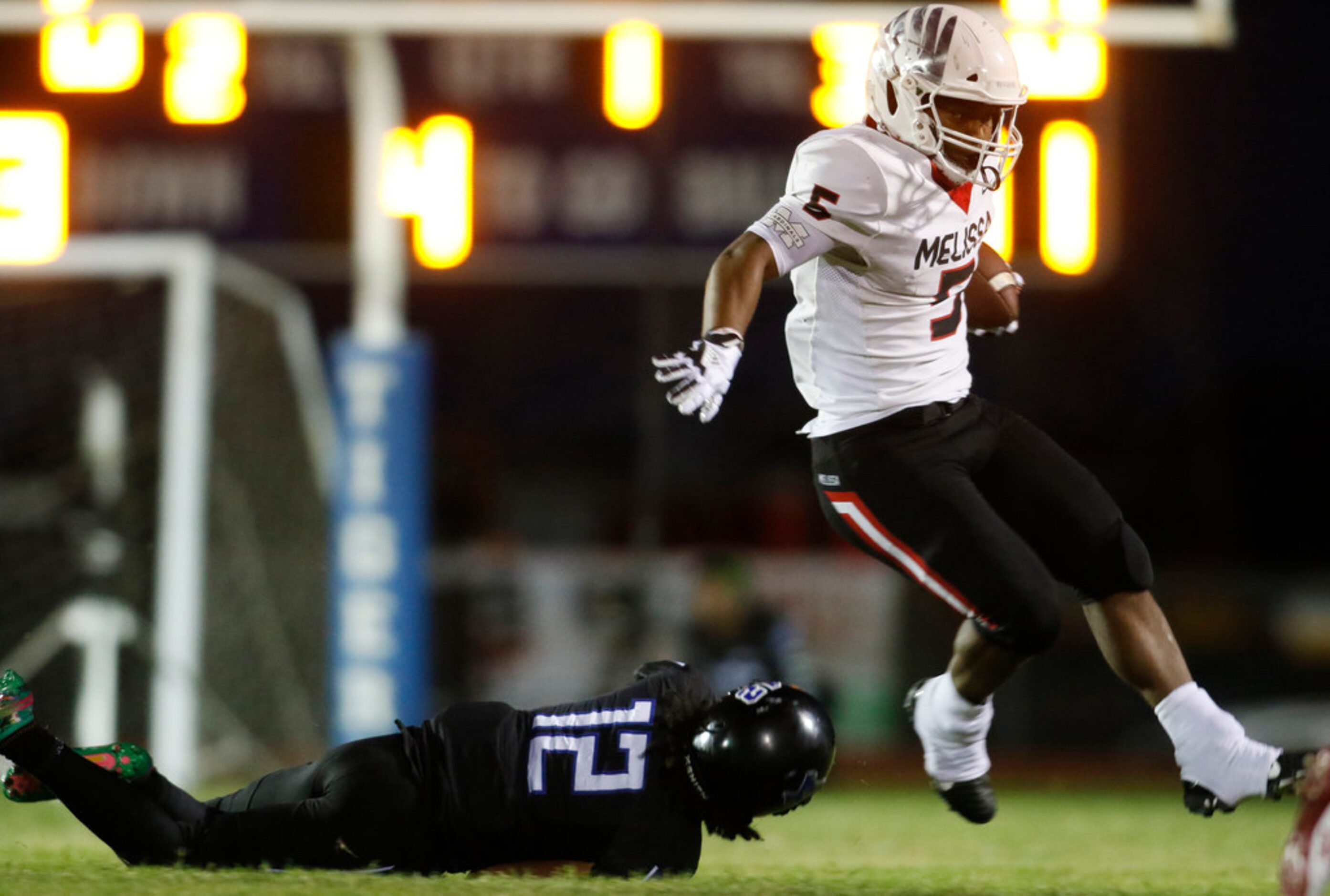 Melissa receiver Ja'Bray Young (5) leaps to avoid the tackle attempt by Trinity Christian...