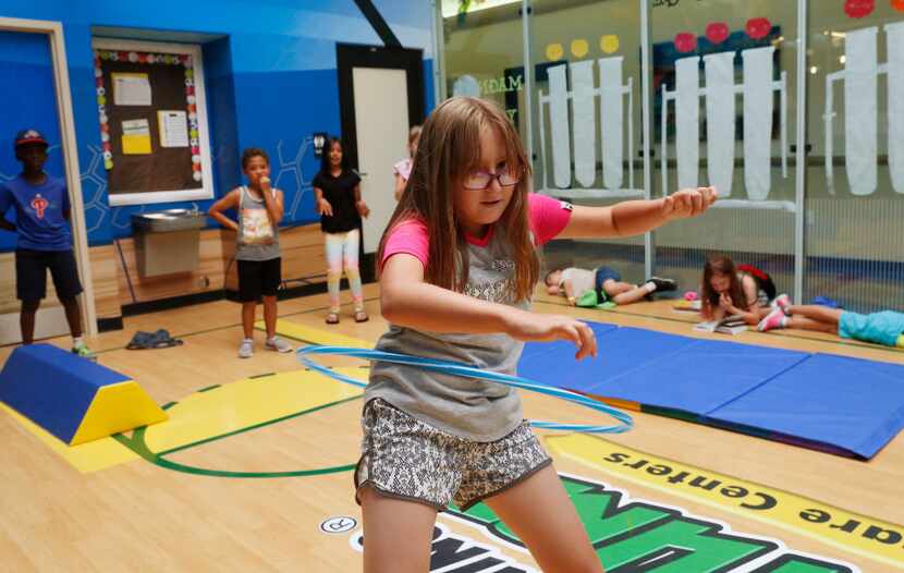 Natalie Summers, 9, counts to 10 at the hula-hoop station as she participates in a small...