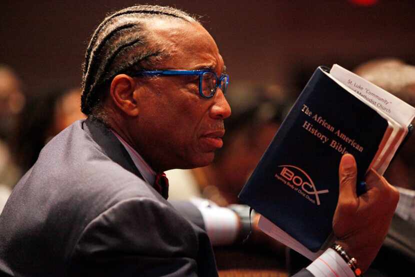 Dallas County Commissioner John Wiley Price holds his Bible as he listens to author and...