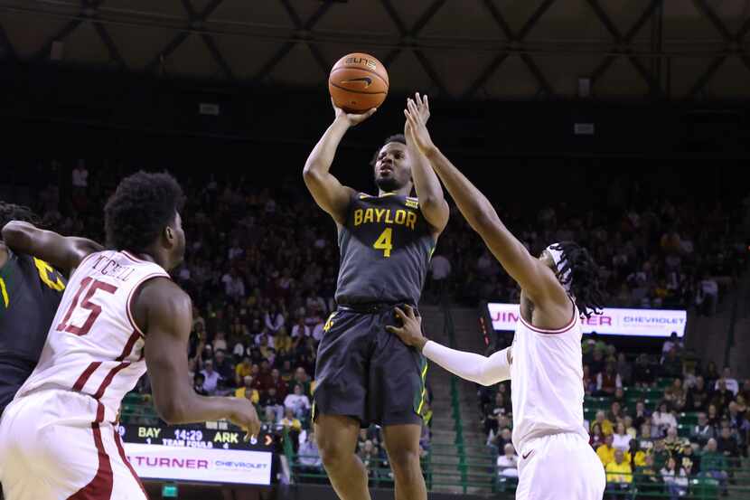 Baylor guard LJ Cryer (4) scores over Arkansas guard Ricky Council IV, right, in the first...