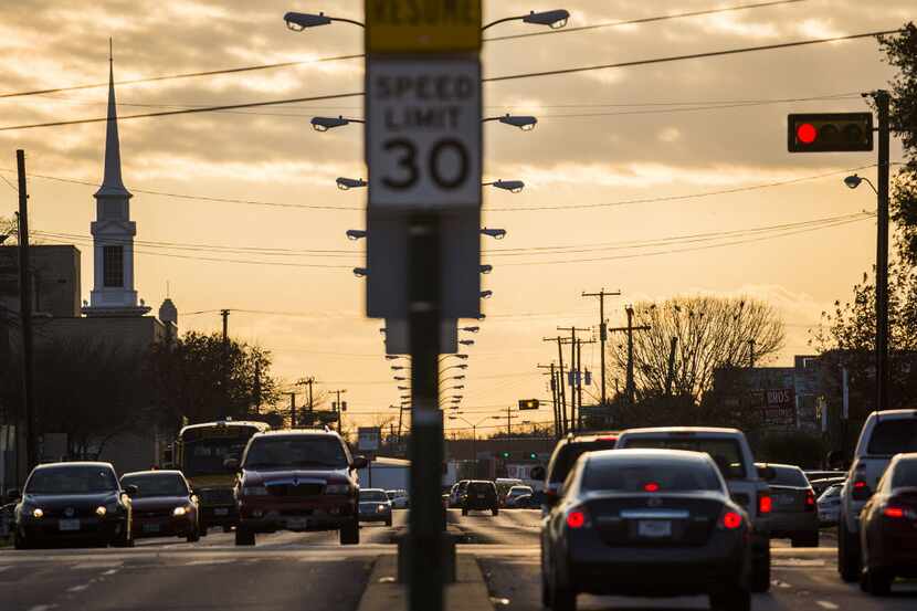 Cars wait at a stoplight on Jefferson Boulevard as the sun sets on Thursday, Jan. 14, 2016,...