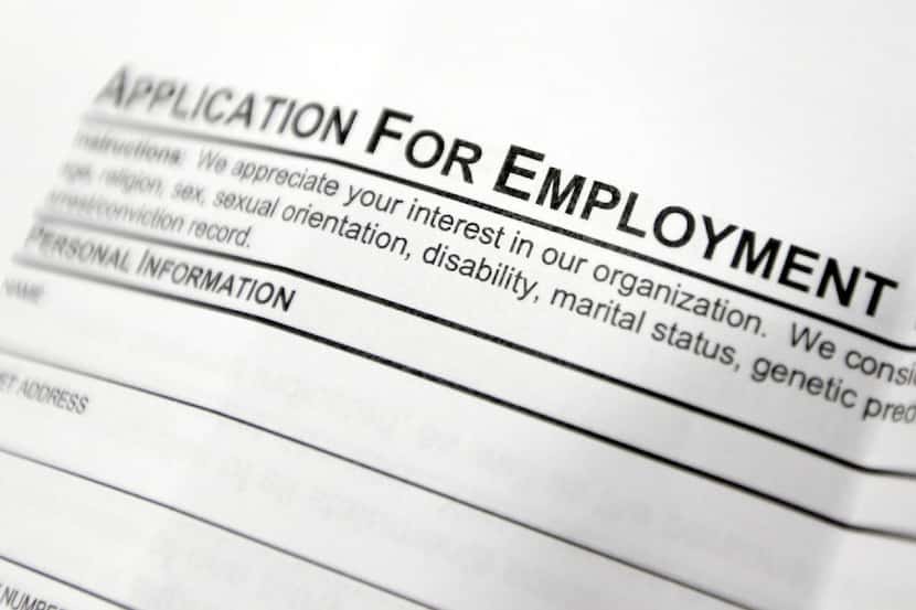 File photo shows an employment application form on a table during a job fair. (AP Photo/Mike...