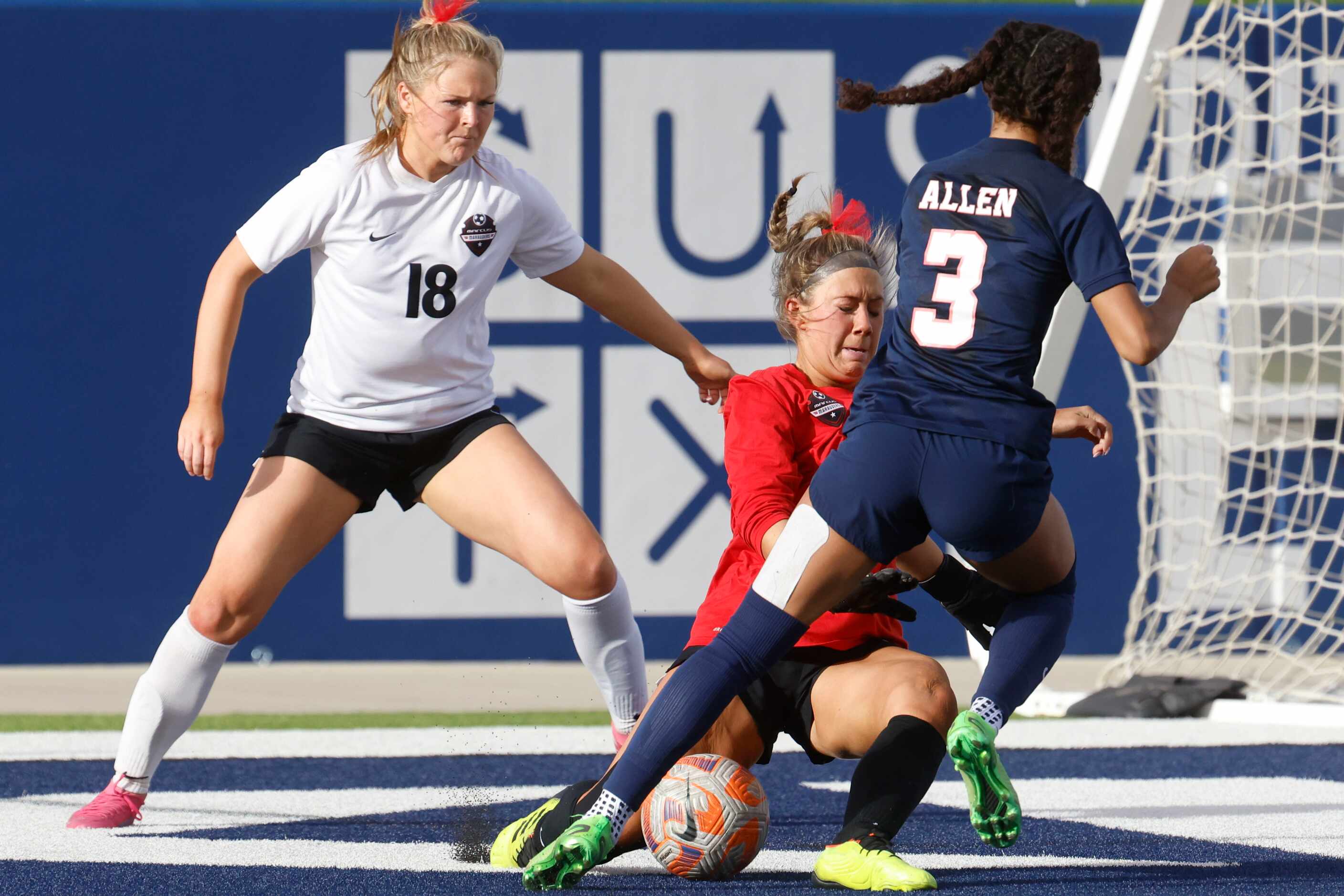 Allen’s Ava McDonald (right) attempts to score past Marcus’s goalkeeper Bry Russell (center)...