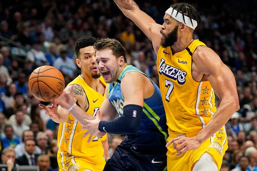 The Dallas Mavericks' Luka Doncic (77) loses the ball as he drives between the Los Angeles...