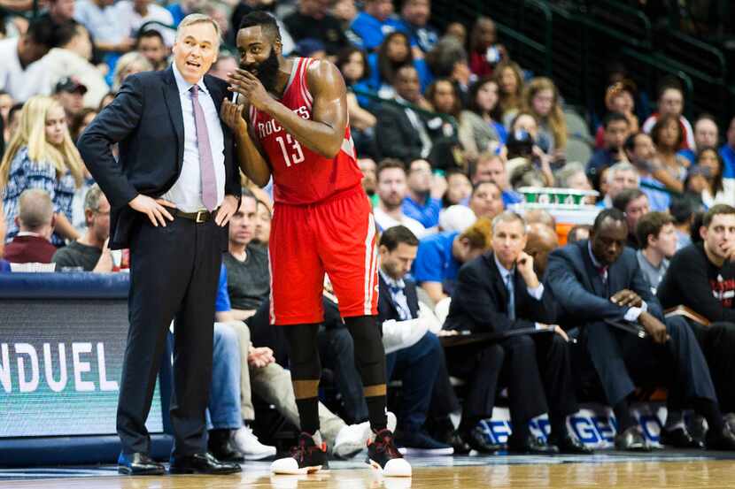 Houston Rockets guard James Harden (13) whispers to head coach Mike D'Antoni during the...