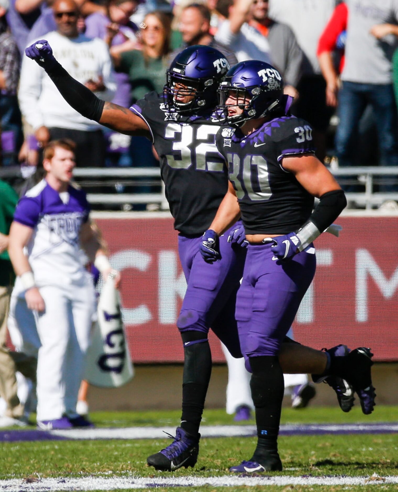 TCU Horned Frogs defensive end Ochaun Mathis (32) and linebacker Garret Wallow (30)...