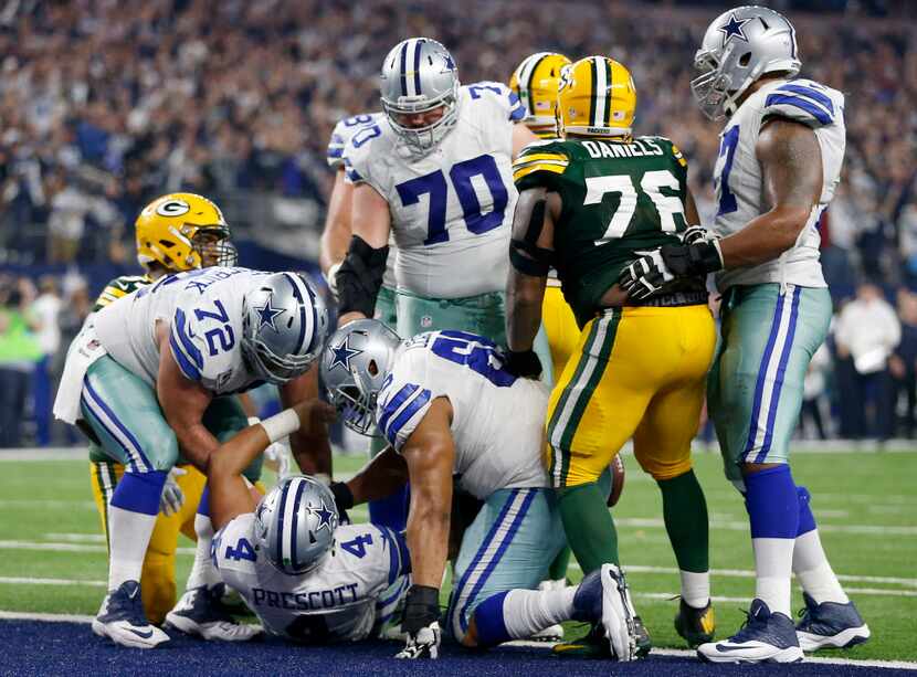 Dallas Cowboys quarterback Dak Prescott (4) gets help to get up from center Travis Frederick...