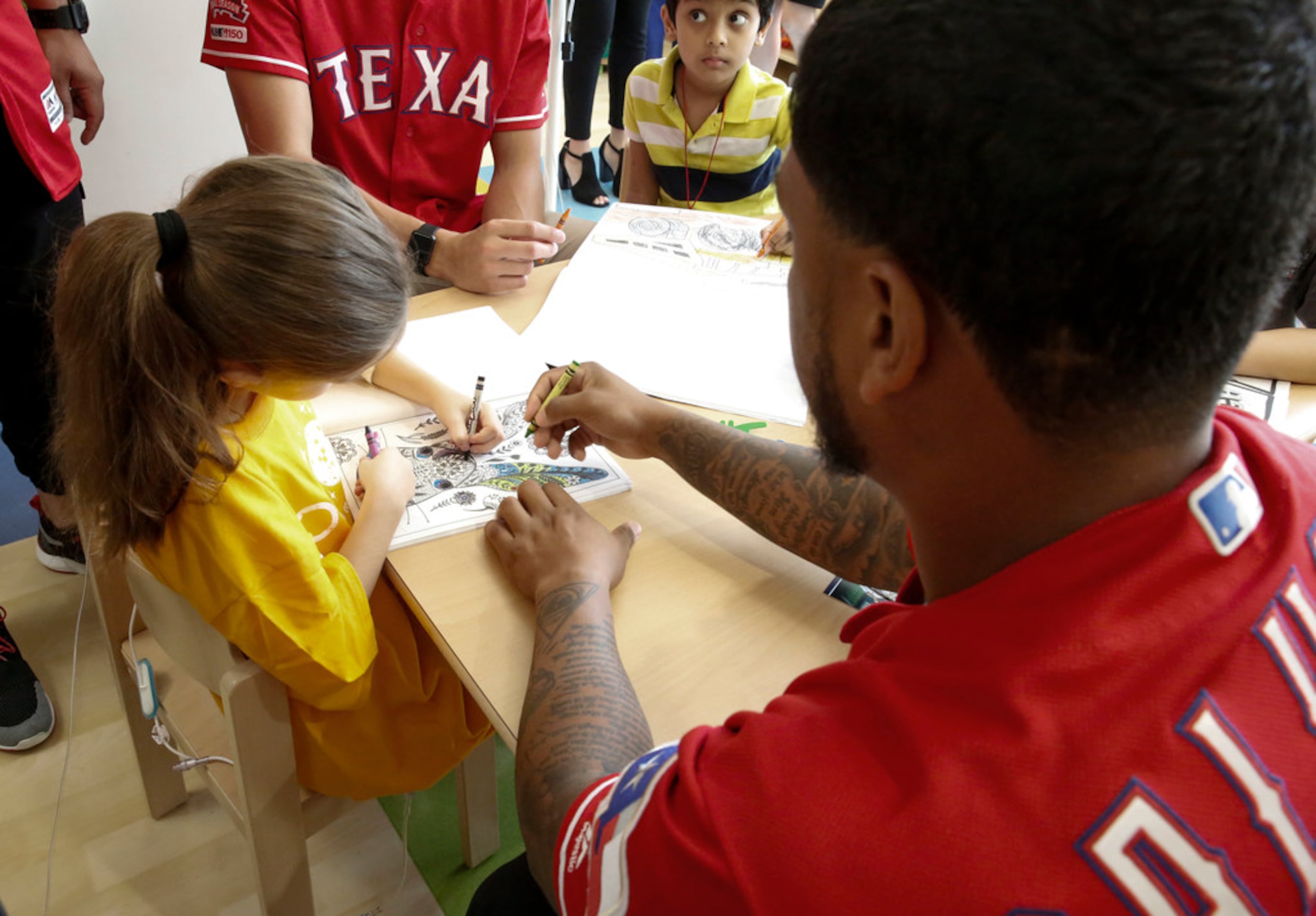 Texas Rangers outfielder Willie Calhoun colors with 7-year-old patient Danielle Gonzalez at...