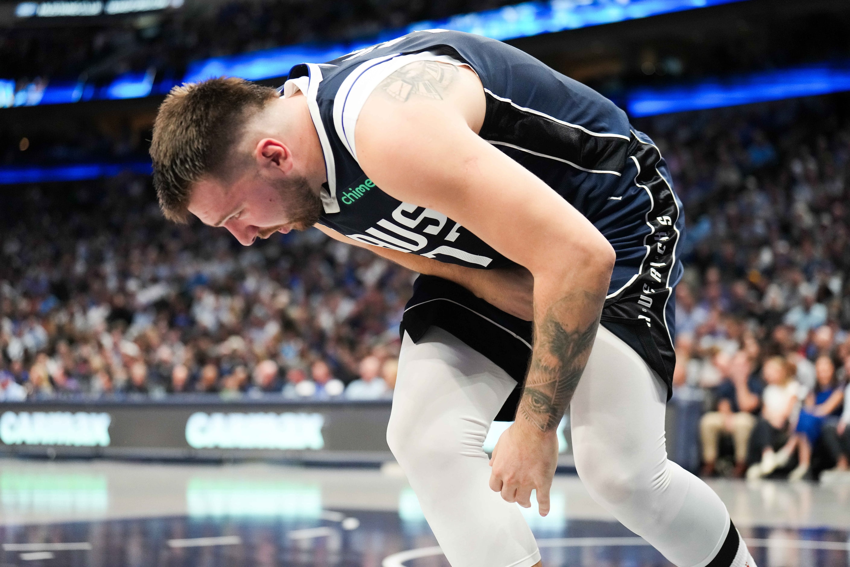 Dallas Mavericks guard Luka Doncic reacts after a collision with San Antonio Spurs forward...