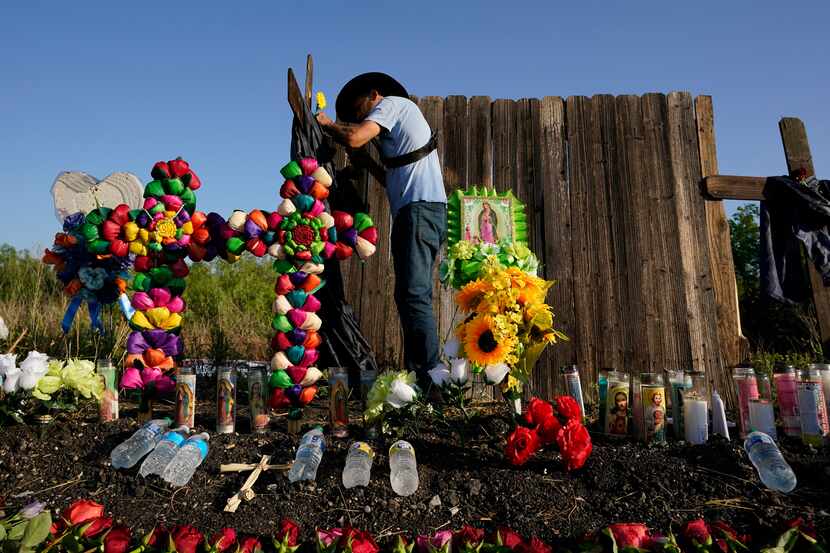Roberto Marquez of Dallas adds a flower to a makeshift memorial at the site where officials...