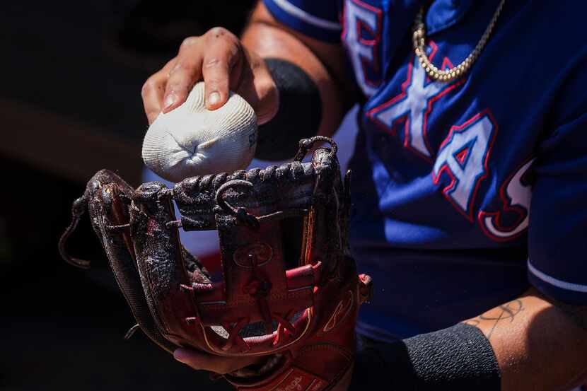 Texas Rangers second baseman Rougned Odor puts rosin on his mitt before a spring training...