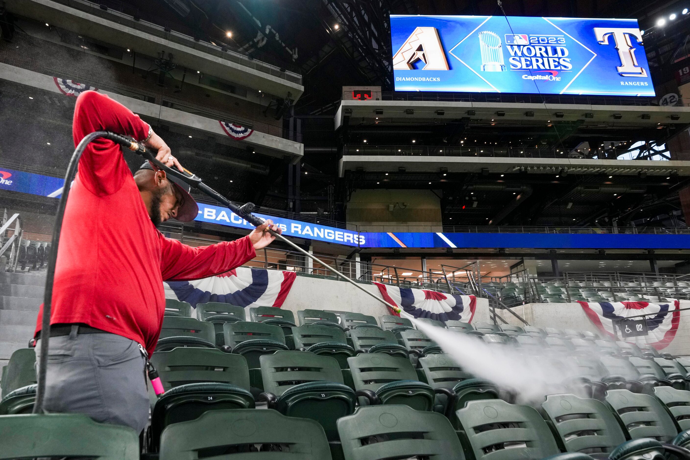 Julio Espinoza pressure washes seats at Globe Life Field in preparation for the World Series...