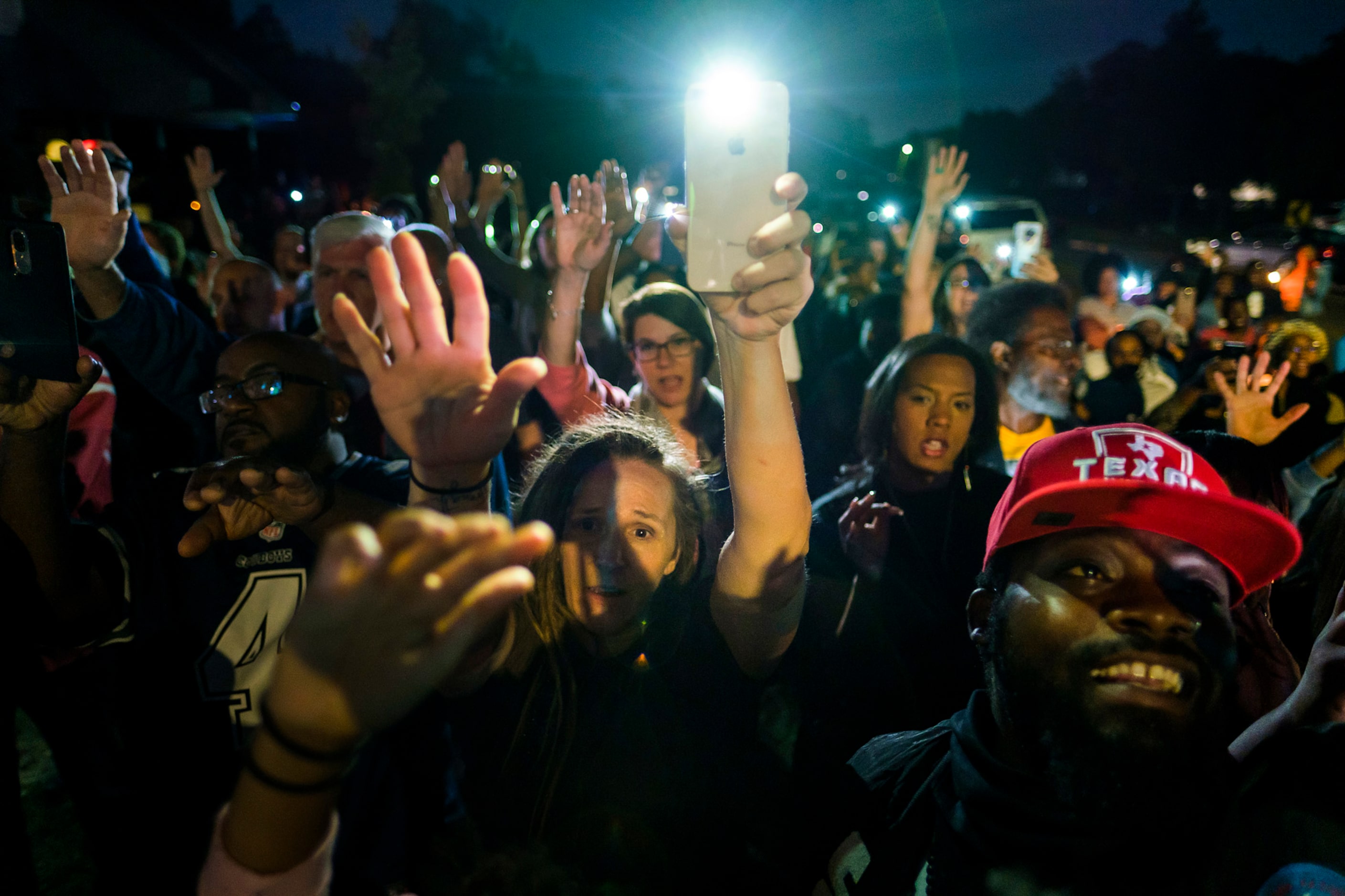 A large crowd gathers outside the house where Atatiana Jefferson was shot and killed, during...