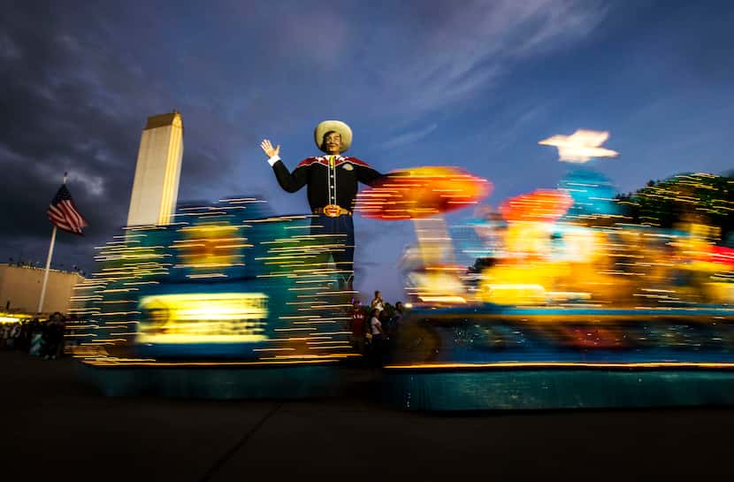 Floats roll past Big Tex during the Starlight Parade at the State Fair of Texas in Dallas on...