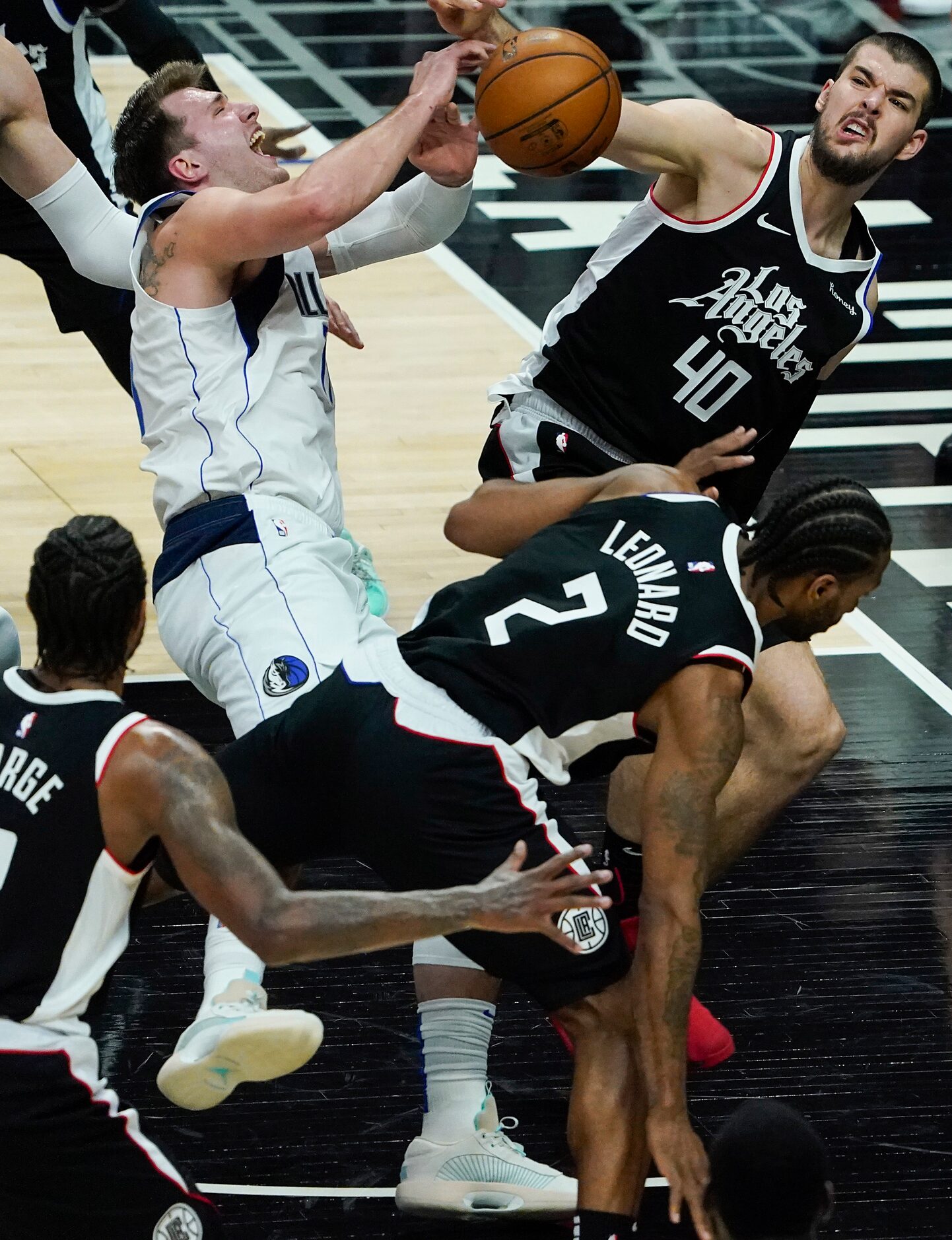 Dallas Mavericks guard Luka Doncic (77) is fouled as he tries to drive between LA Clippers...