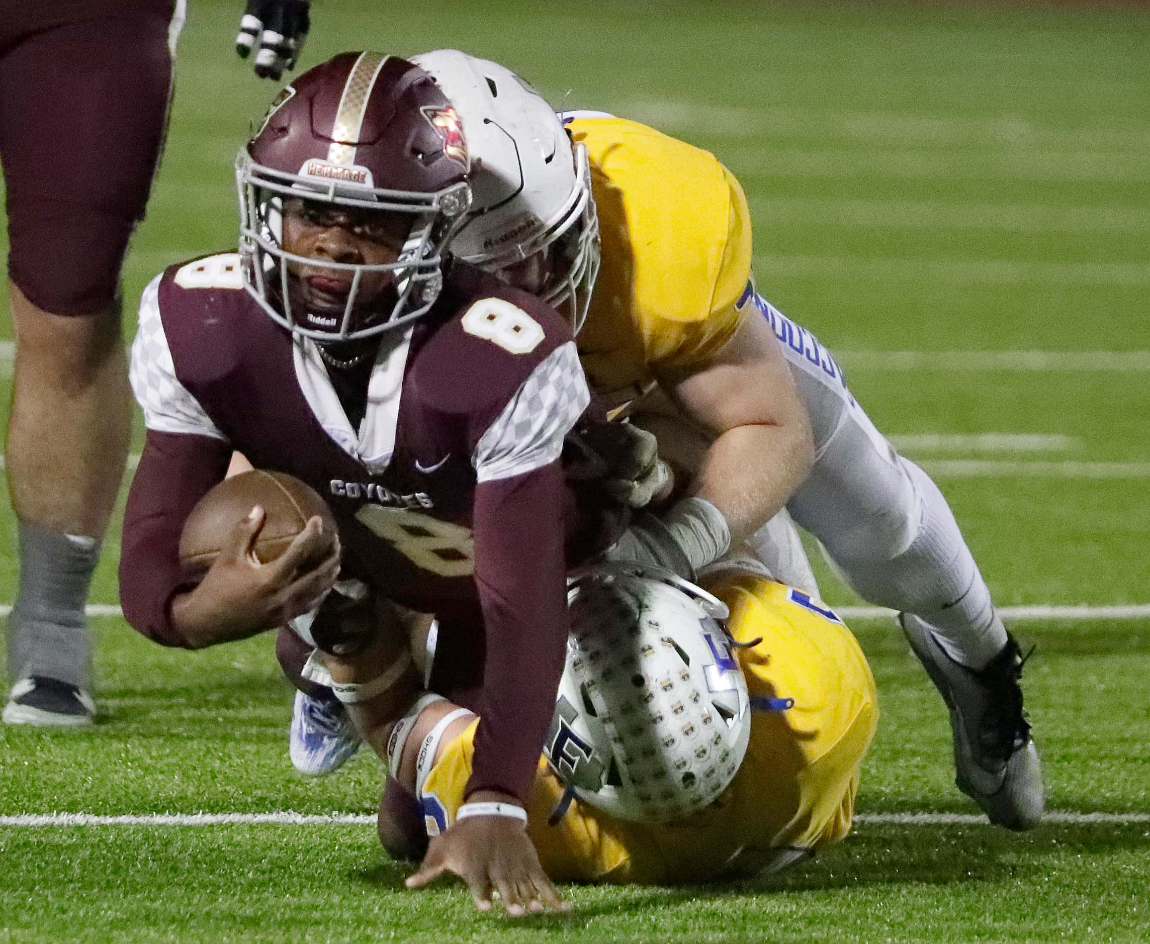 Frisco Heritage High School quarterback Jiyere Cogshell (8) is tackled by Frisco High School...