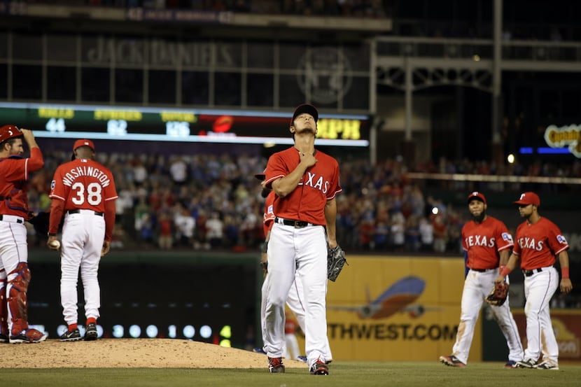 Texas Rangers' Yu Darvish of Japan looks skyward as he walks off the field in the ninth...
