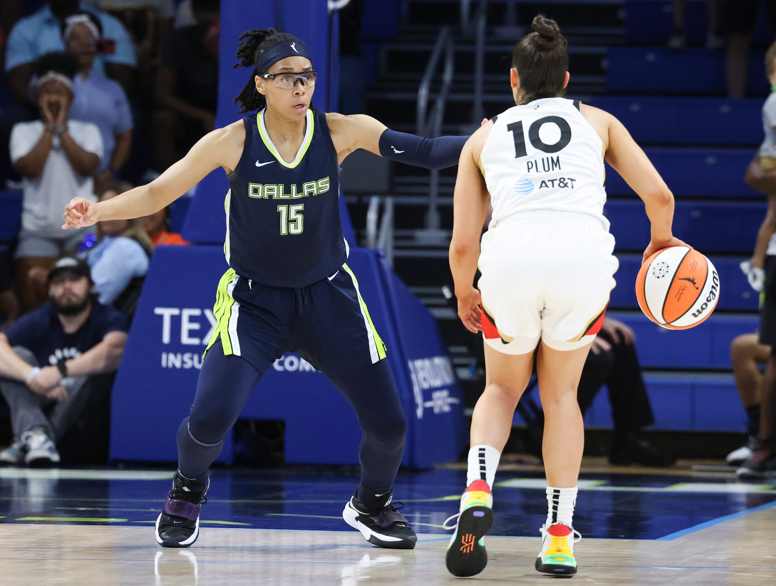 Dallas Wings guard Allisha Gray (15) defends Las Vegas Aces guard Kelsey Plum (10) as she...