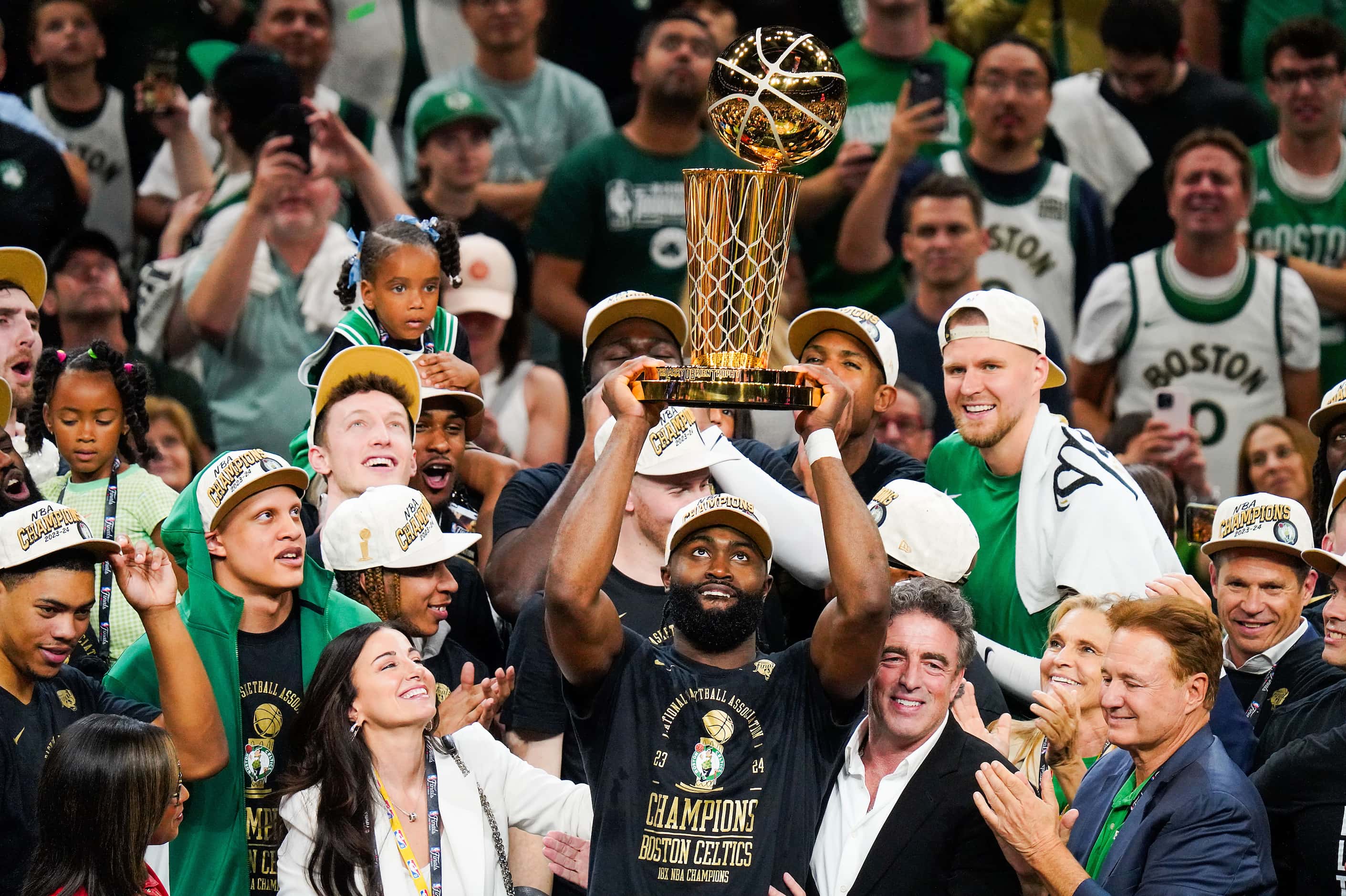 Boston Celtics guard Jaylen Brown lifts the Larry O'Brien Championship Trophy after a...