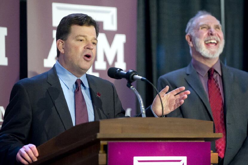 Texas A&M president Michael Young (right) laughs as new A&M athletic director Scott Woodward...