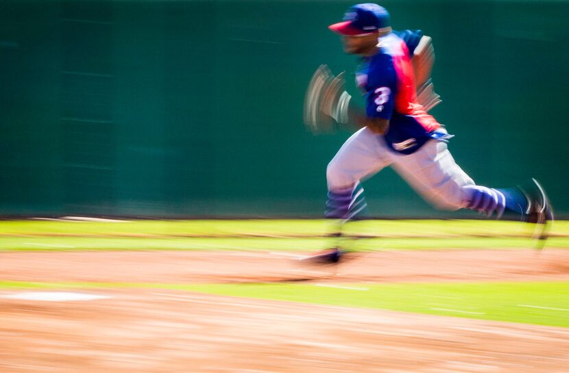 Texas Rangers oufielder Delino DeShields runs a base running drill during the first...