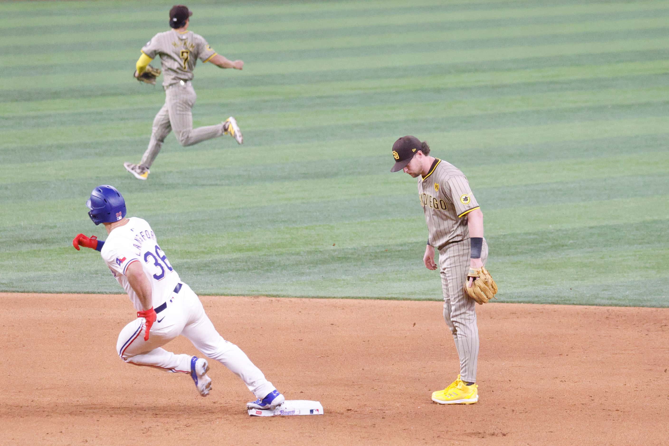 Texas Rangers outfielder Wyatt Langford (36) steps on second base and runs to third base as...