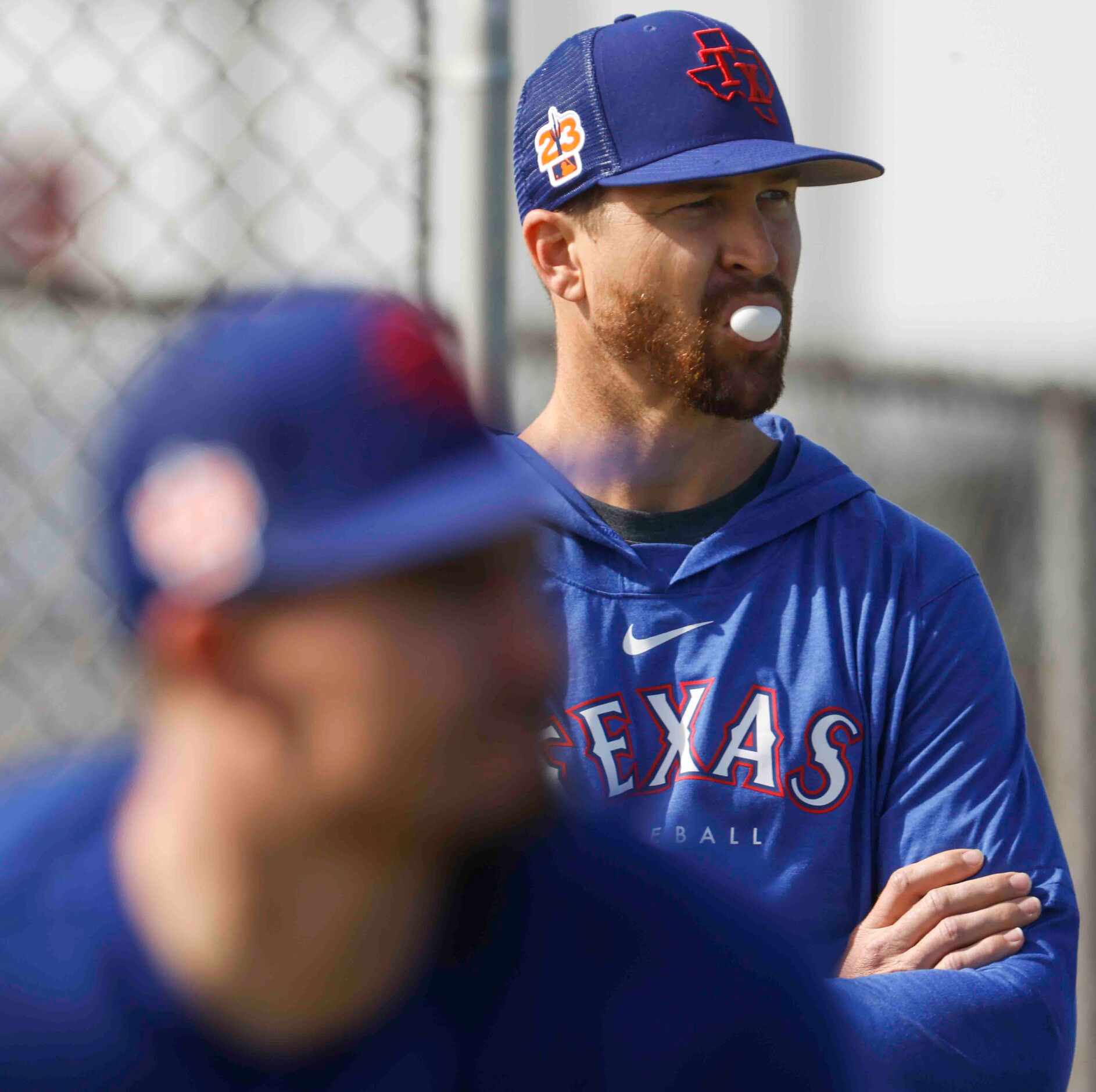 Texas Rangers pitcher Jacob deGrom observes his teammates during a spring training workout...