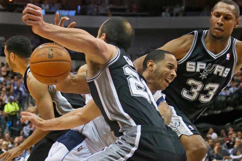 Dallas' Devin Harris loses possession as he tries to navigate heavy traffic in the lane in...