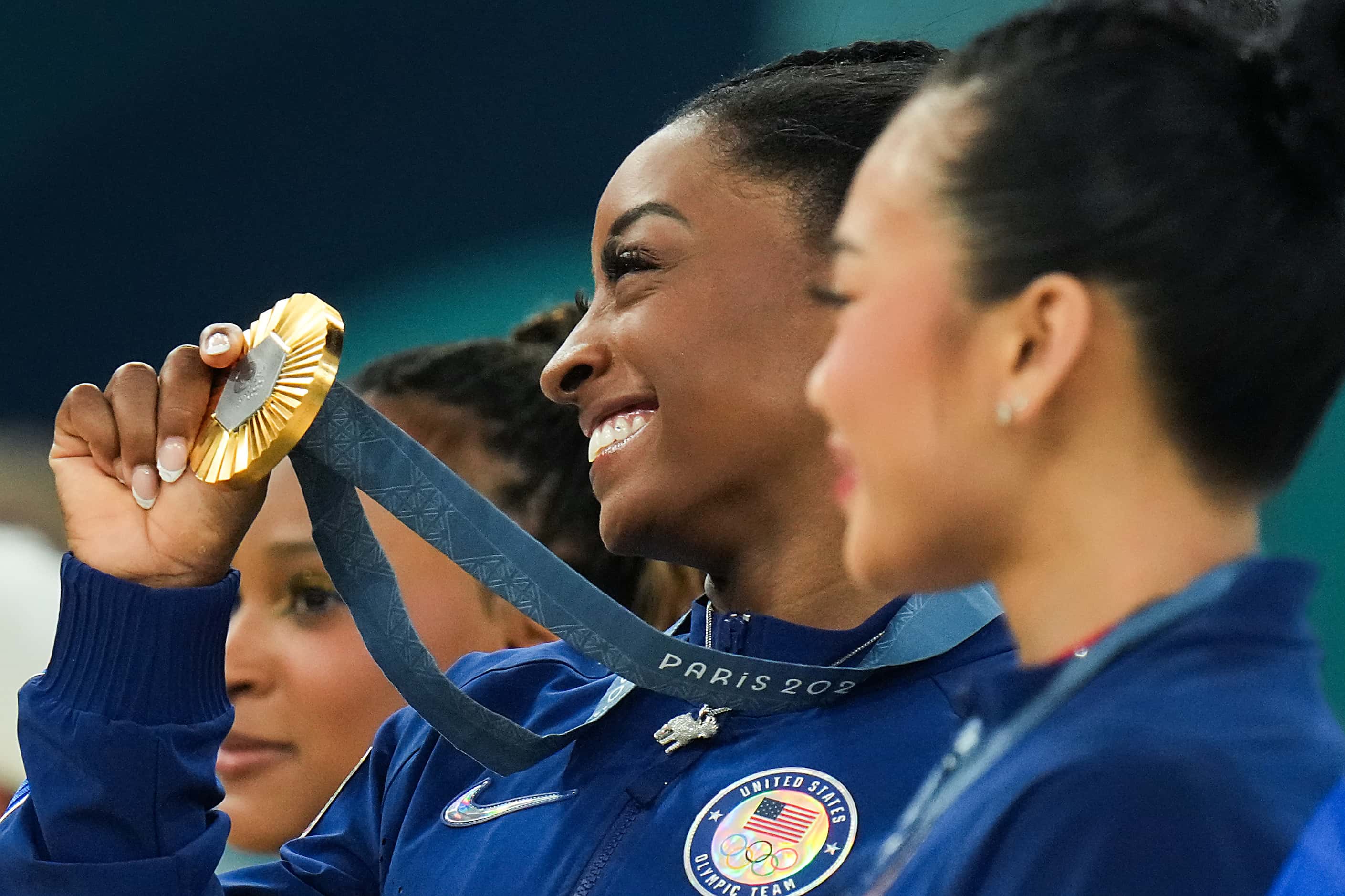 Simone Biles of the United States shows off her gold medal for winning the women’s...