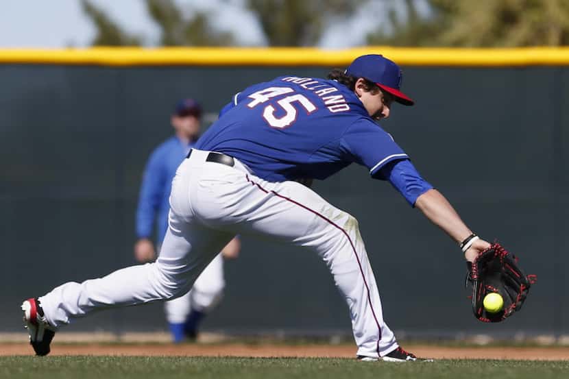 Texas Rangers pitcher Derek Holland makes a play while participating in a softball mock...