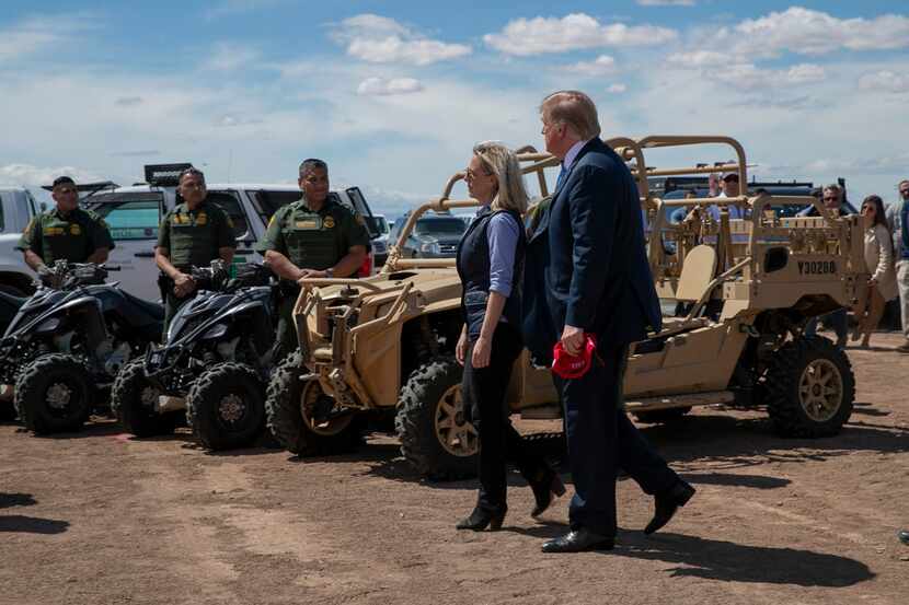 President Donald Trump walks with Homeland Security Secretary Kirstjen Nielsen as they visit...