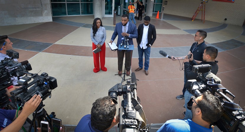 Dallas attorney Lee Merritt is flanked by K.C. Fox, left, a women's rights activist and...