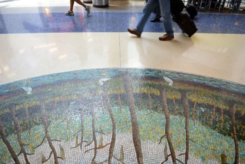 
Airport patrons walk past Cypress Trees by Arthello Black. 
