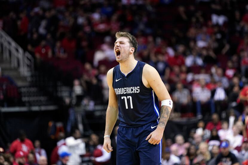 Dallas Mavericks' Luka Doncic reacts after a teammate's 3-pointer against the Houston...
