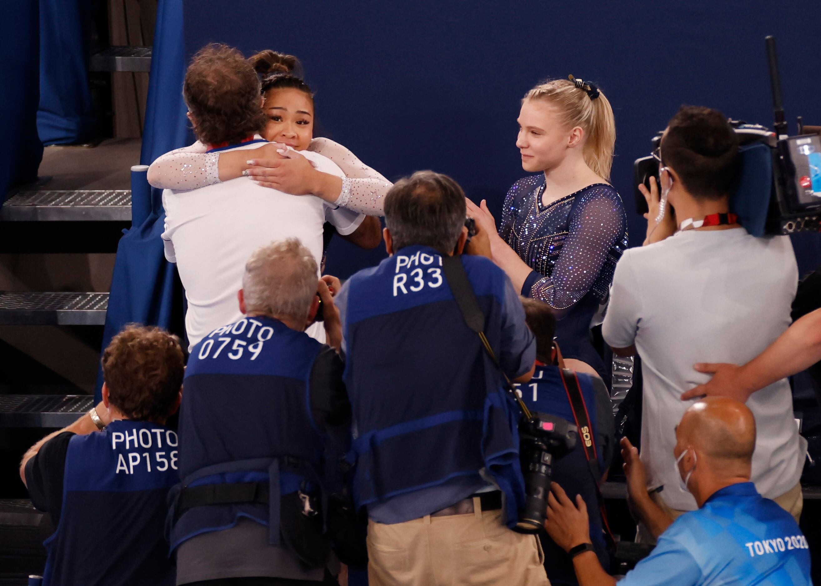 USA’s Sunisa Lee hugs her coach Jeff Graba as Jade Carey looks on after Lee won gold in the...