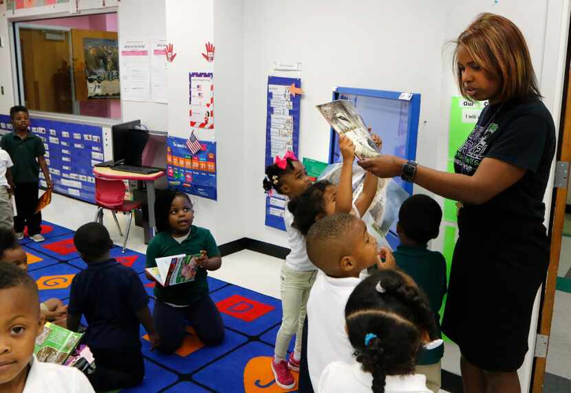 Jisel Johnson (center), 4, holding a book, tries to get the attention of Principal Onjaleke...