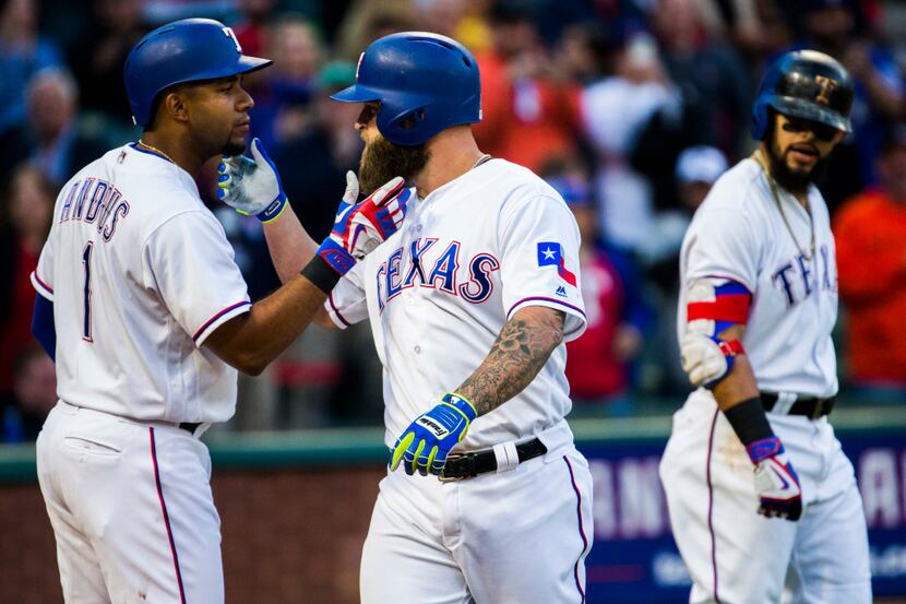 Texas Rangers shortstop Elvis Andrus (1) and first baseman Mike Napoli (5) touch each...