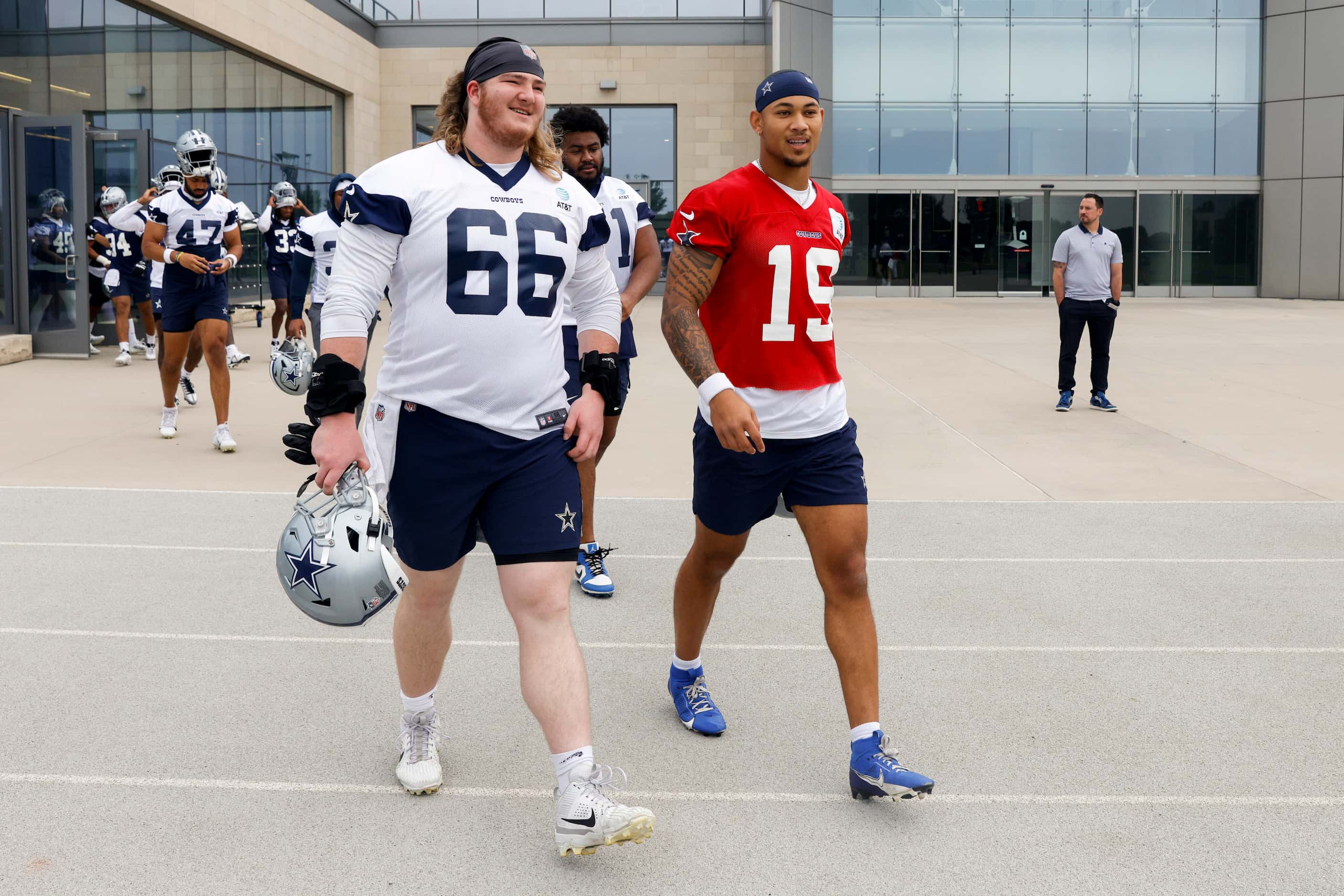Dallas Cowboys guard T.J. Bass (66) and quarterback Trey Lance (15) take the field before...