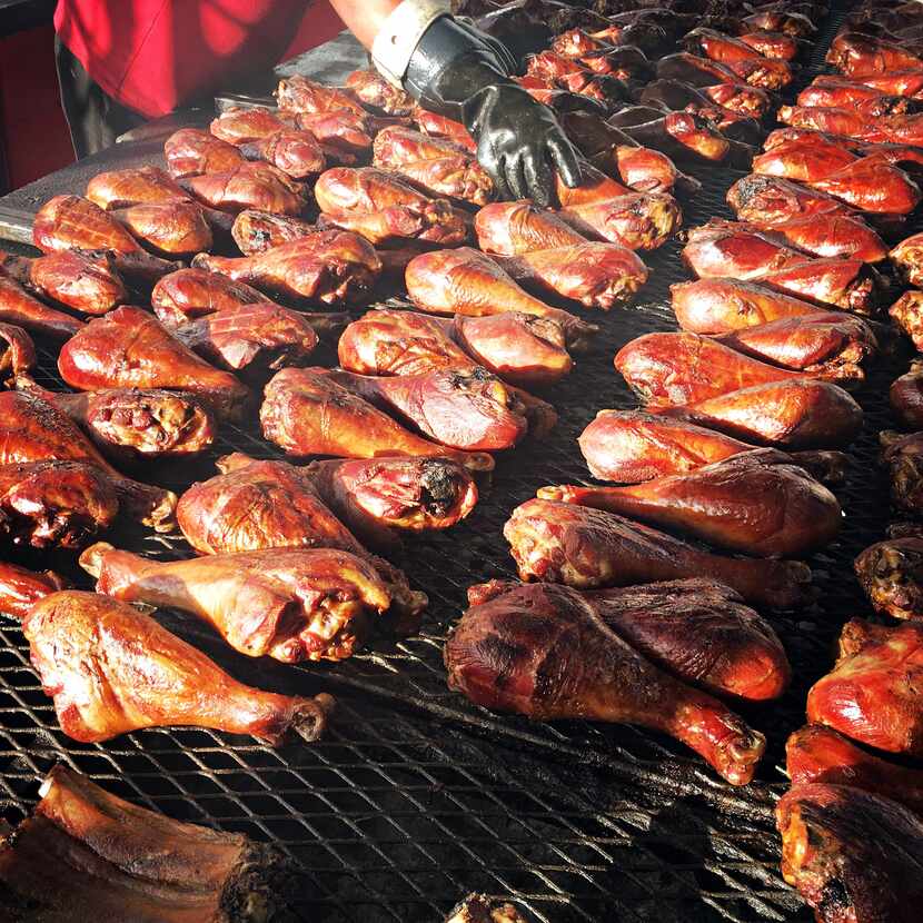 A vendor adjusts turkey legs on the smoker during the State Fair of Texas at Fair Park on...