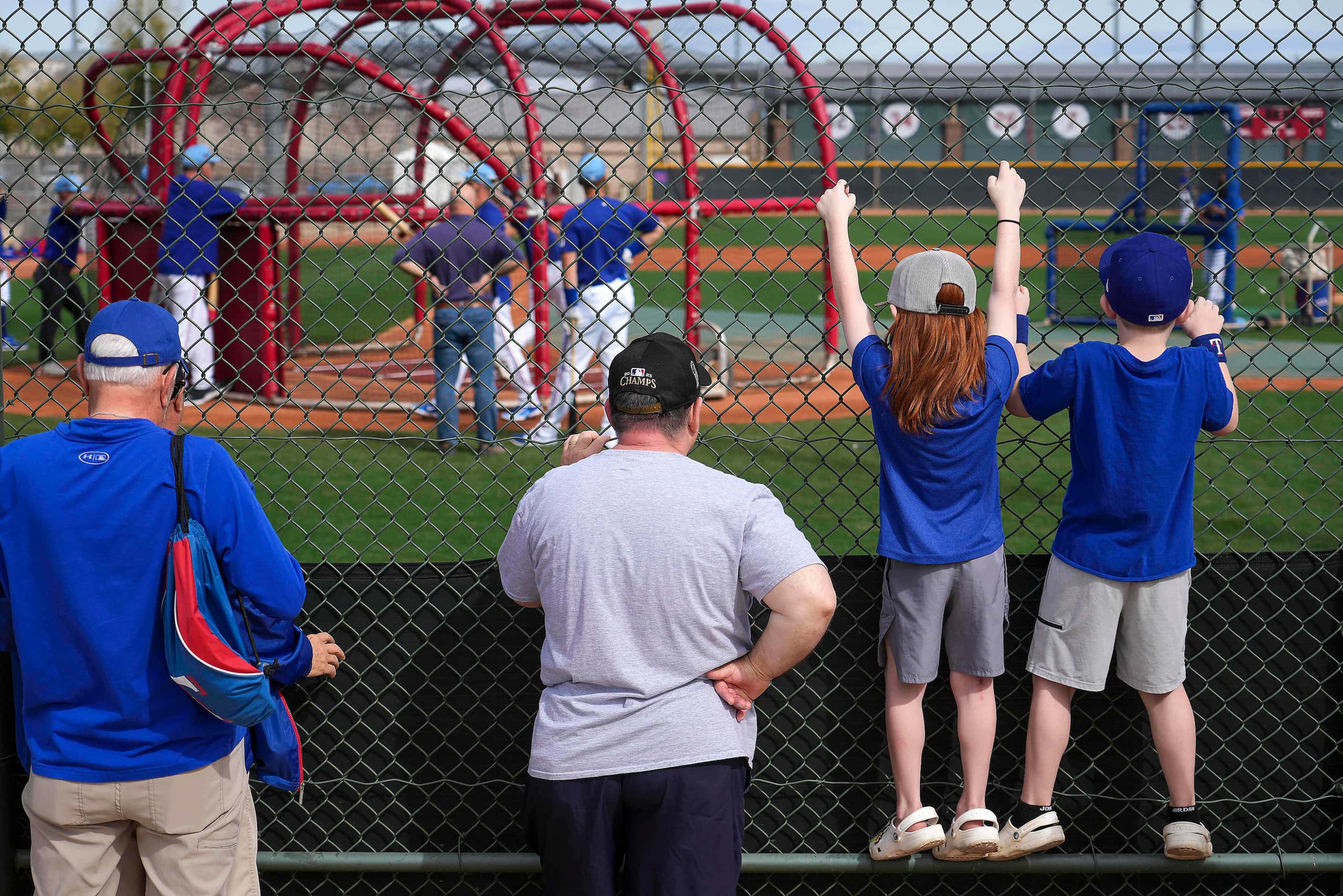 Fans watch Texas Rangers players take batting practice during a spring training workout at...