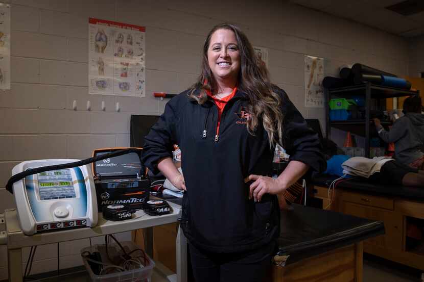 Jordan Hart, head athletic trainer for Lancaster High School, stands next to an ultra sound...