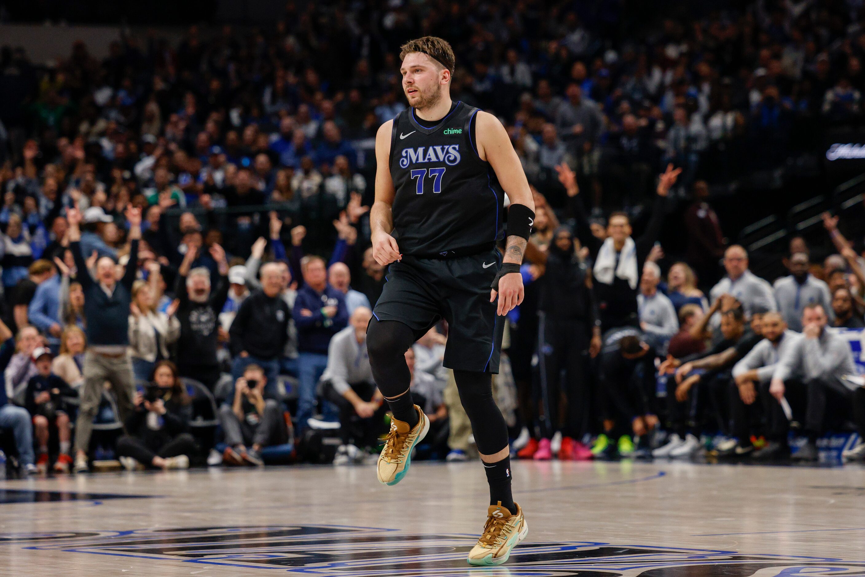 Dallas Mavericks guard Luka Doncic (77) skips down court after making a three-pointer during...